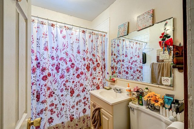 bathroom featuring toilet, vanity, and a shower with shower curtain