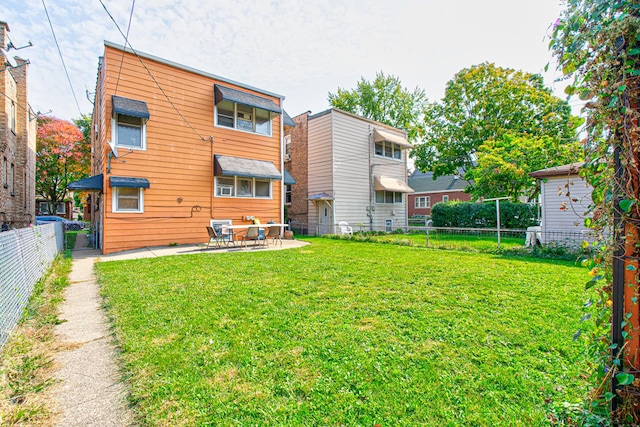 rear view of property featuring a lawn and a patio