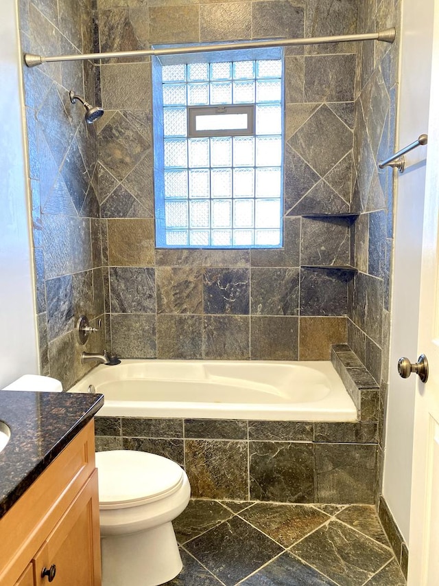 full bathroom featuring toilet, vanity, and tiled shower / bath