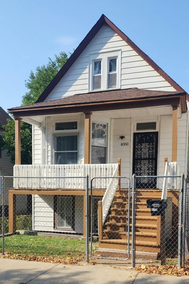 8350 S Muskegon Ave, Chicago, IL 60617 - view of front facade featuring a porch, a fenced front yard, and a gate