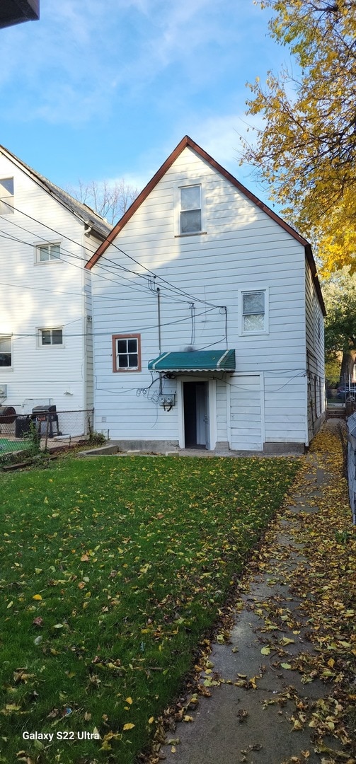 rear view of house featuring a yard