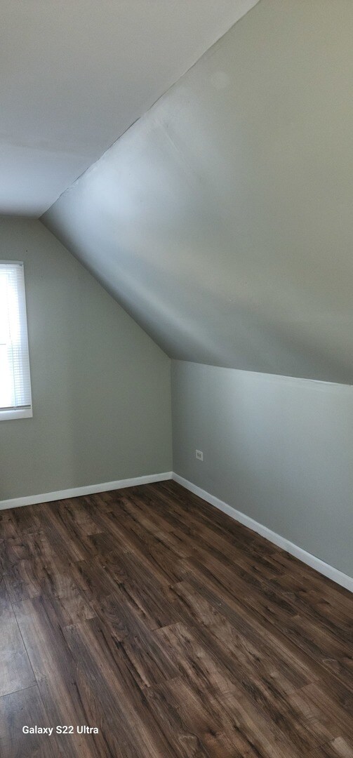 bonus room featuring dark hardwood / wood-style flooring and lofted ceiling