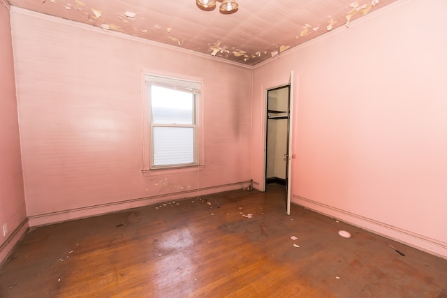 spare room featuring wood-type flooring and ornamental molding