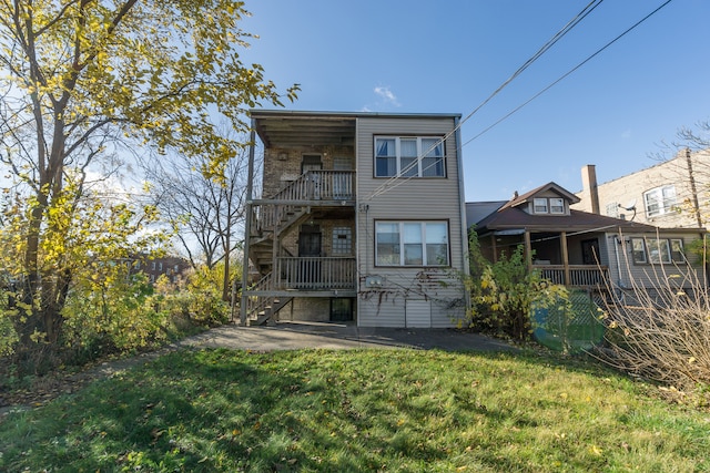 rear view of property featuring a lawn