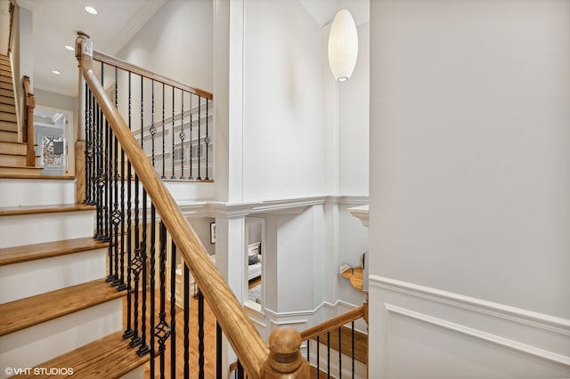 stairs featuring hardwood / wood-style flooring and ornamental molding