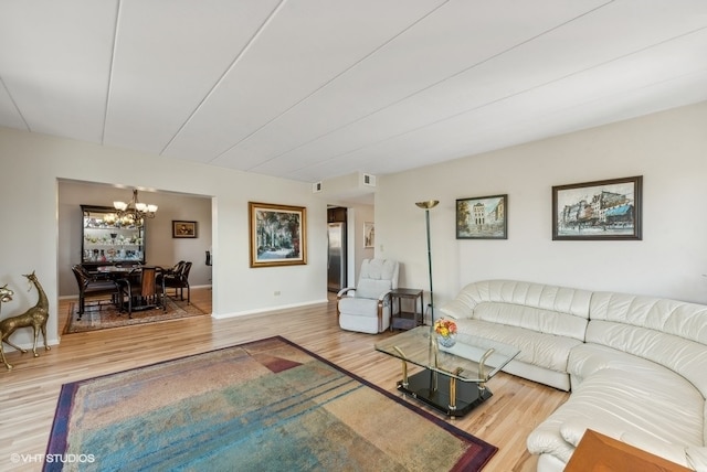 living room with an inviting chandelier and hardwood / wood-style flooring