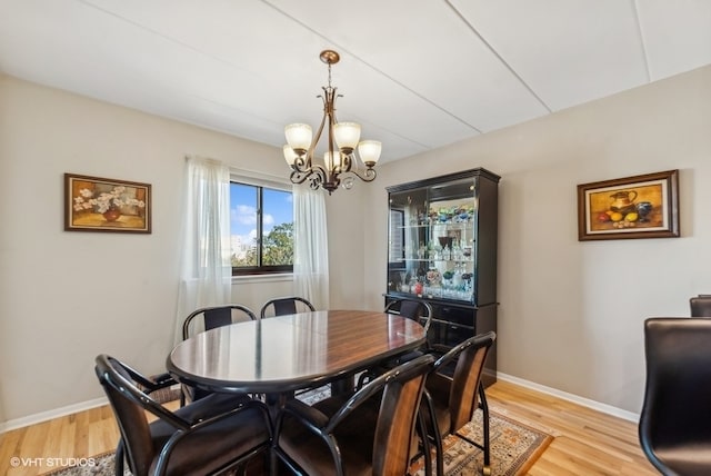 dining space featuring an inviting chandelier and light hardwood / wood-style flooring