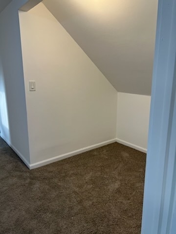 bonus room featuring lofted ceiling and dark colored carpet