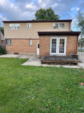 back of property featuring a yard and a wooden deck