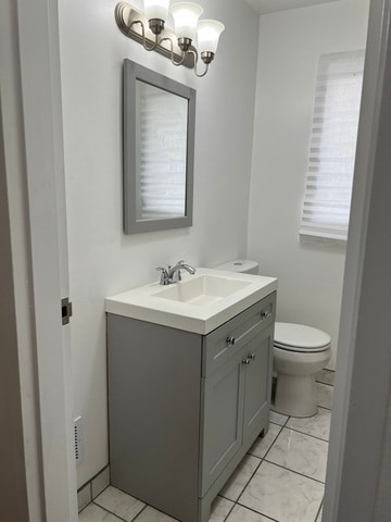 bathroom featuring vanity, toilet, and an inviting chandelier