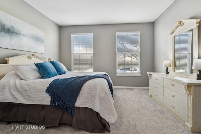 bedroom featuring light carpet and multiple windows