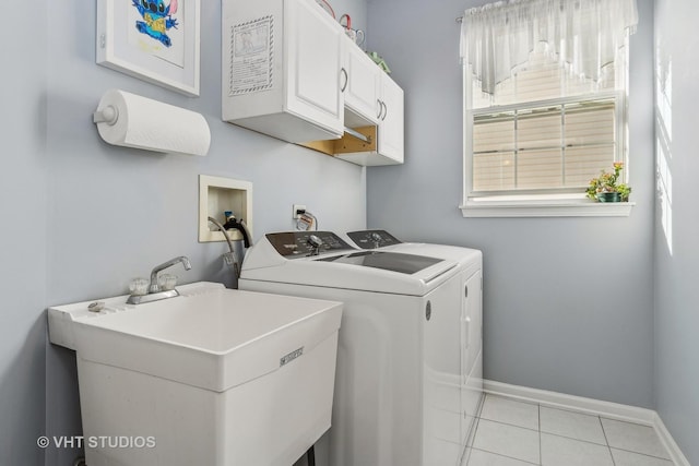 clothes washing area with cabinets, sink, light tile patterned floors, and separate washer and dryer