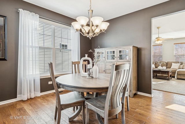 dining space featuring ceiling fan with notable chandelier and hardwood / wood-style floors