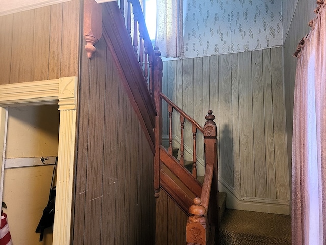 stairs featuring wood walls