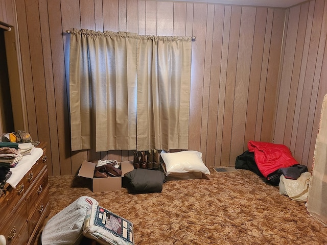 carpeted bedroom with wooden walls