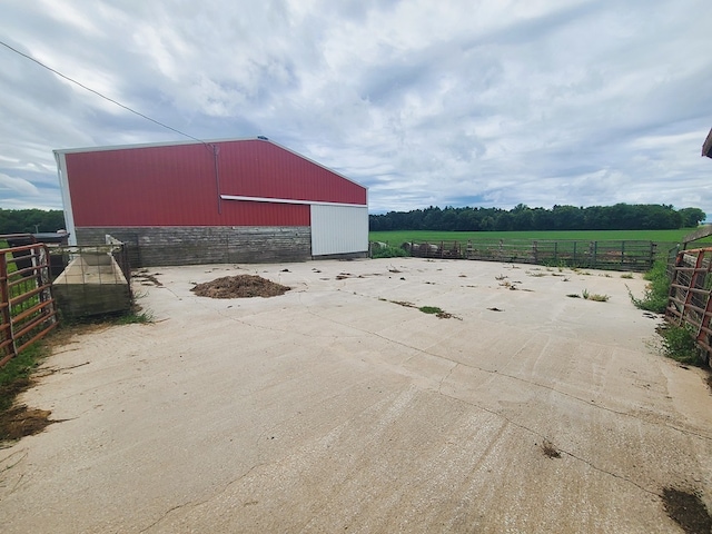 view of patio / terrace featuring an outbuilding and a rural view