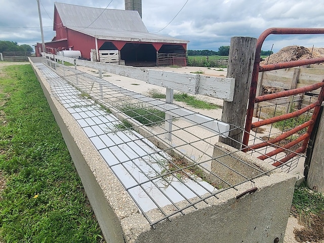 view of gate featuring a rural view and an outdoor structure