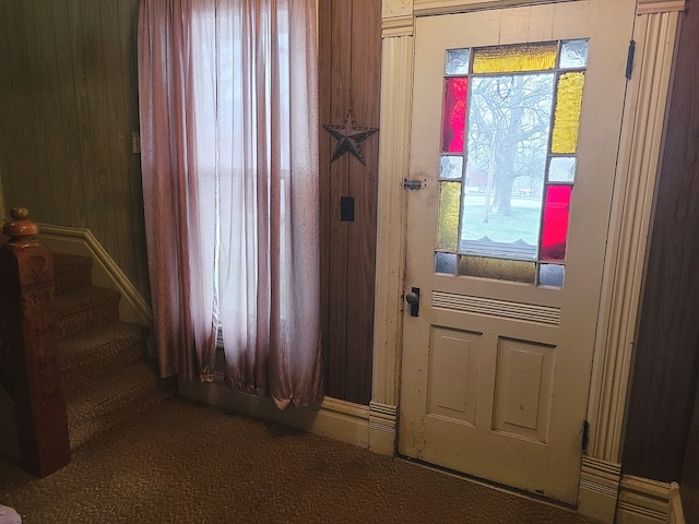 entryway with wooden walls and carpet floors