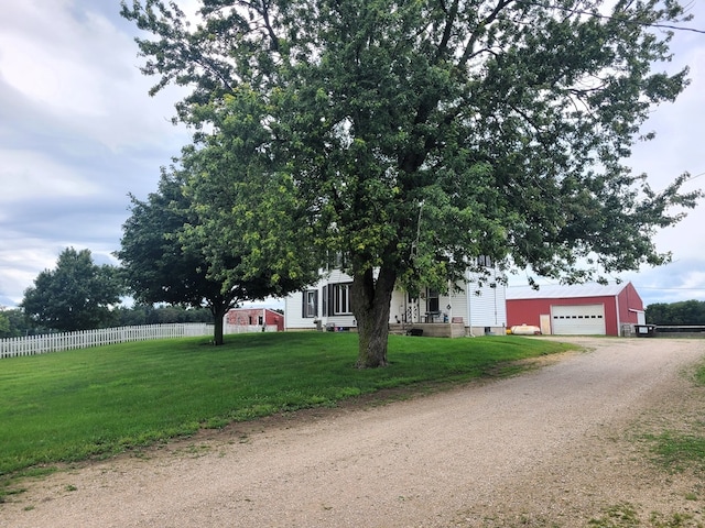 view of front of property featuring a garage, an outbuilding, and a front lawn