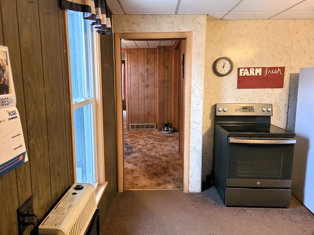 kitchen featuring heating unit, electric range, a drop ceiling, and carpet