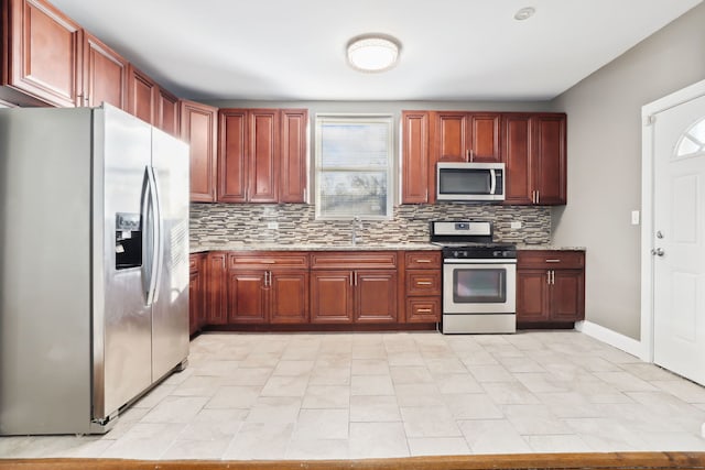 kitchen featuring light stone countertops, sink, appliances with stainless steel finishes, and tasteful backsplash