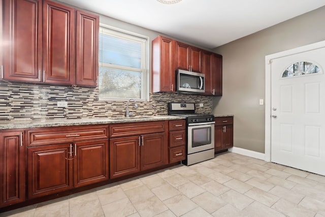 kitchen with tasteful backsplash, light stone countertops, sink, and stainless steel appliances