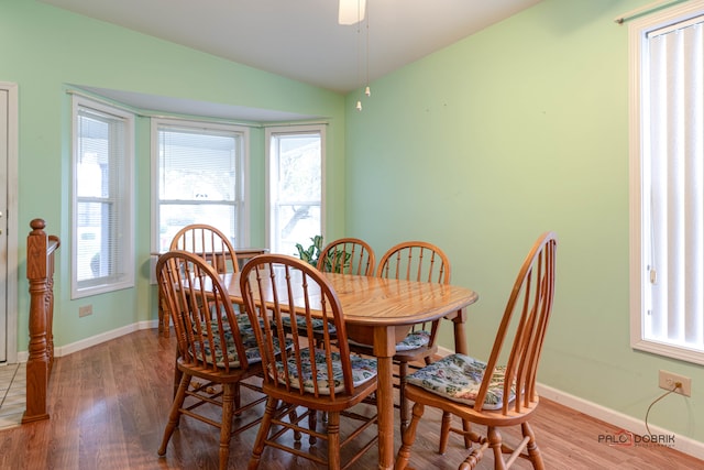 dining space with hardwood / wood-style floors and vaulted ceiling