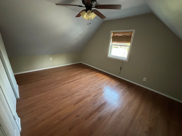 additional living space with dark hardwood / wood-style floors, vaulted ceiling, and ceiling fan