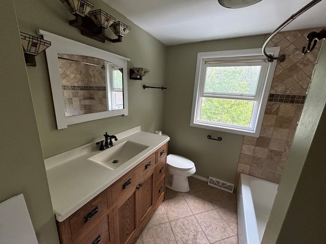 full bathroom featuring tile patterned flooring, vanity, tiled shower / bath combo, and toilet