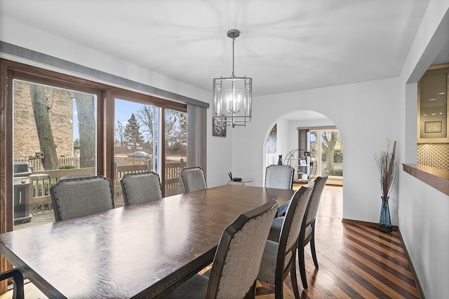 dining area with dark hardwood / wood-style floors and a notable chandelier