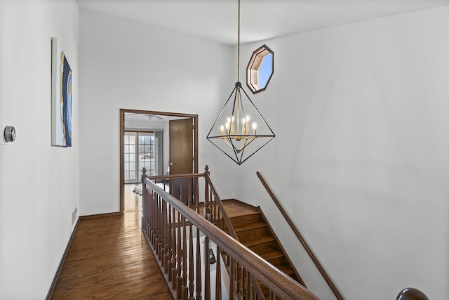 hall with a notable chandelier and dark hardwood / wood-style flooring