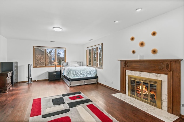 bedroom featuring dark hardwood / wood-style floors and a premium fireplace