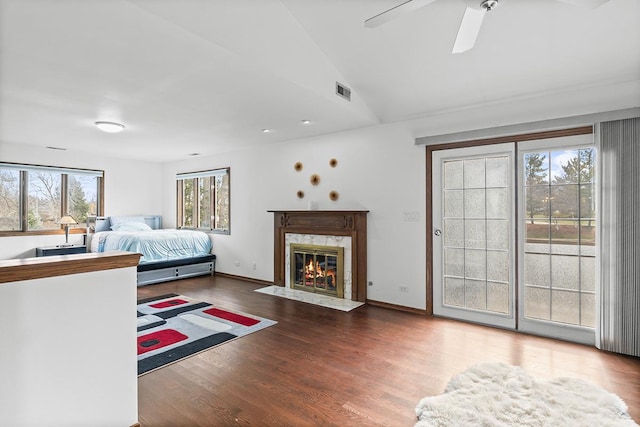 bedroom featuring hardwood / wood-style floors, ceiling fan, and multiple windows