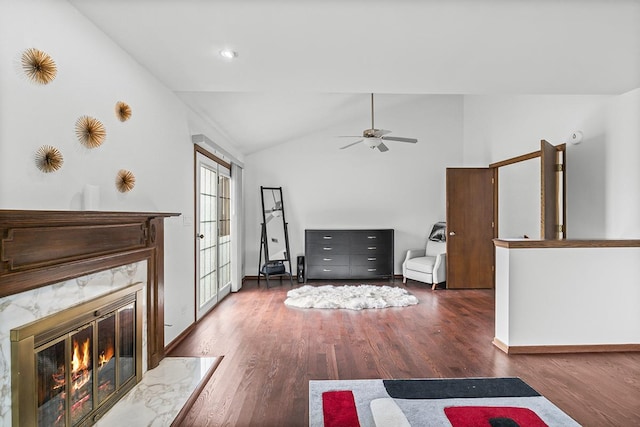 unfurnished living room featuring ceiling fan, a high end fireplace, dark hardwood / wood-style floors, and vaulted ceiling