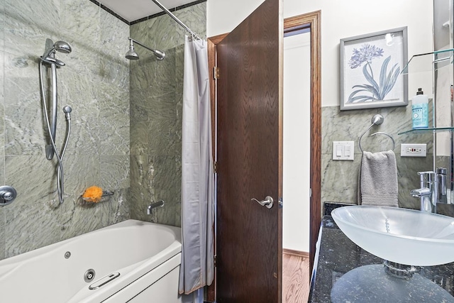 bathroom with sink, wood-type flooring, tile walls, and shower / tub combo with curtain