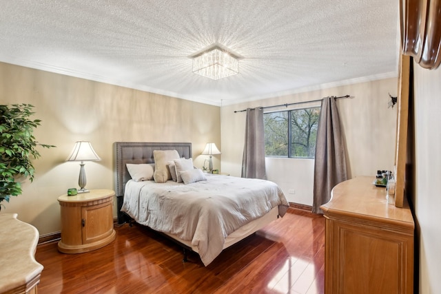 bedroom with wood-type flooring, a textured ceiling, and a notable chandelier