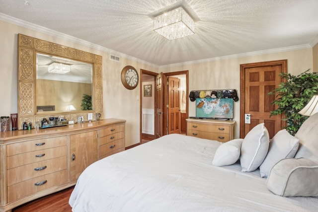 bedroom with a textured ceiling, ornamental molding, dark wood-type flooring, and an inviting chandelier