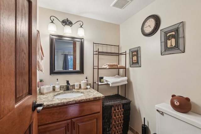 bathroom featuring vanity and toilet