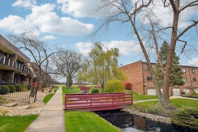 view of community with a water view and a yard