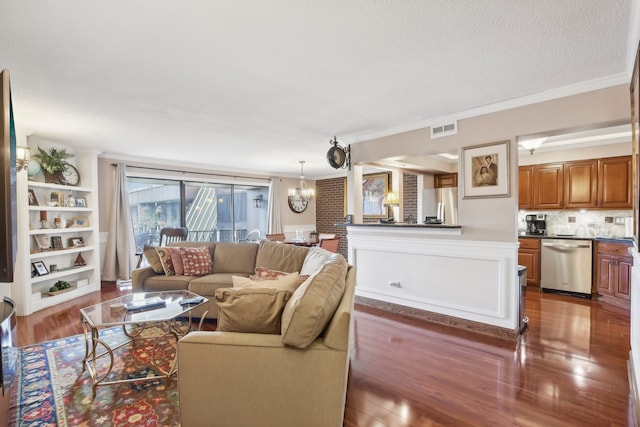 living room featuring crown molding, dark wood-type flooring, and a chandelier