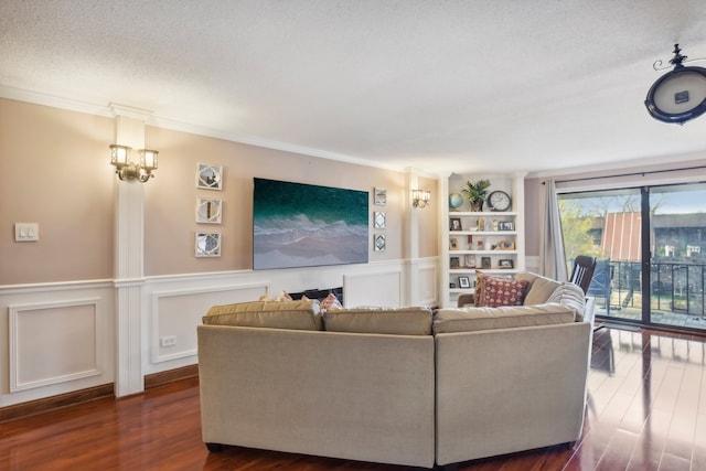 living room featuring built in features, dark wood-type flooring, a textured ceiling, and ornamental molding