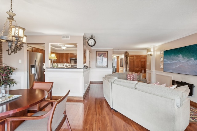 living room featuring wood-type flooring and crown molding