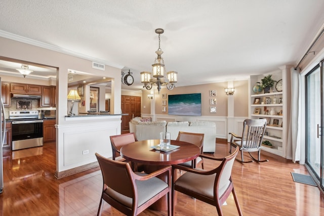 dining room featuring light hardwood / wood-style flooring, a notable chandelier, and crown molding