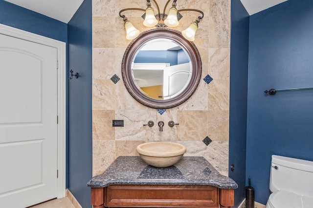 bathroom featuring backsplash, sink, tile walls, and toilet