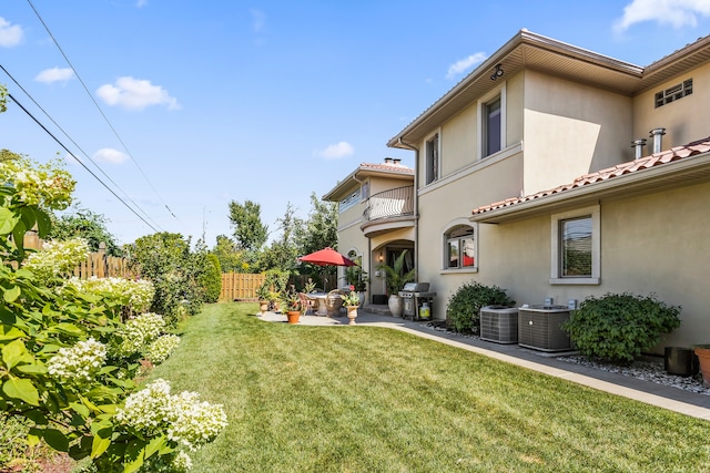 view of yard with a patio, a balcony, and central air condition unit