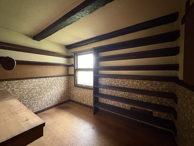 interior space with beam ceiling and a textured ceiling