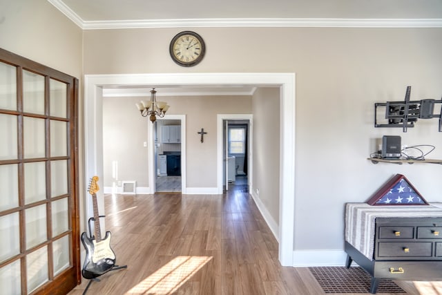 hallway with a chandelier, hardwood / wood-style floors, and ornamental molding