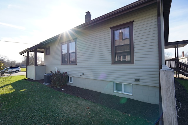 view of property exterior with a lawn and central air condition unit