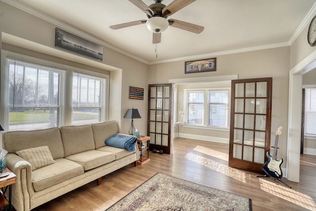 living room with a wealth of natural light, french doors, and light hardwood / wood-style floors