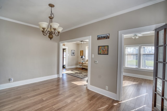 unfurnished dining area with ceiling fan with notable chandelier, light wood-type flooring, and crown molding